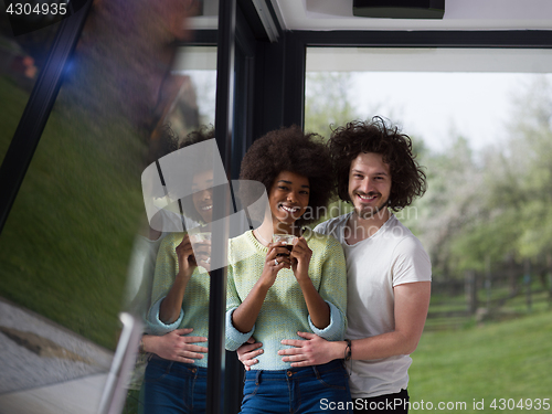 Image of happy multiethnic couple relaxing at modern home indoors