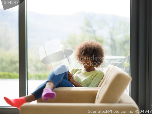 Image of young african american woman at home using digital tablet