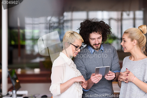 Image of group of Business People Working With Tablet in startup office