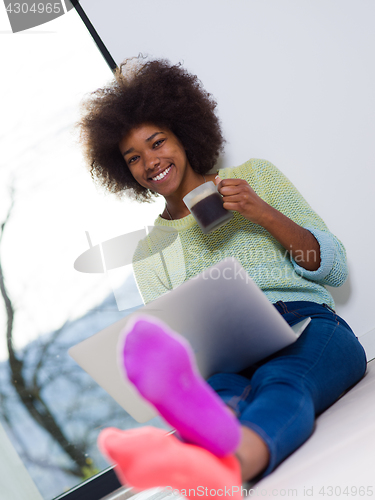 Image of black woman in the living room on the floor