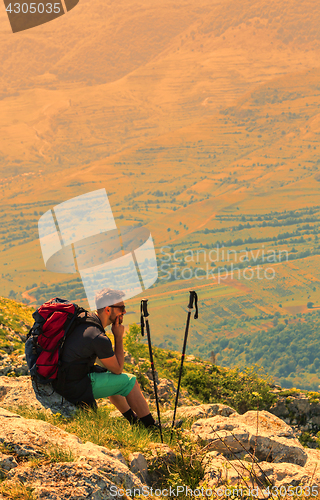 Image of Hiker Resting on Rocks in Mountains