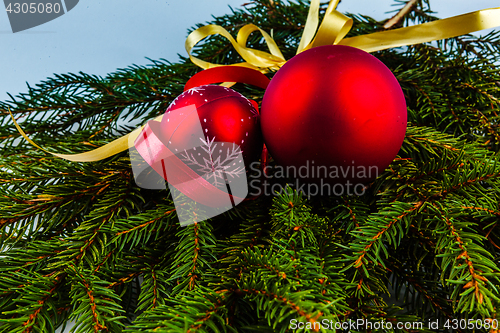 Image of Christmas decorations with red balls and gold ribbons.