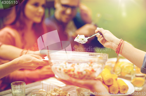 Image of happy friends having dinner at summer garden party