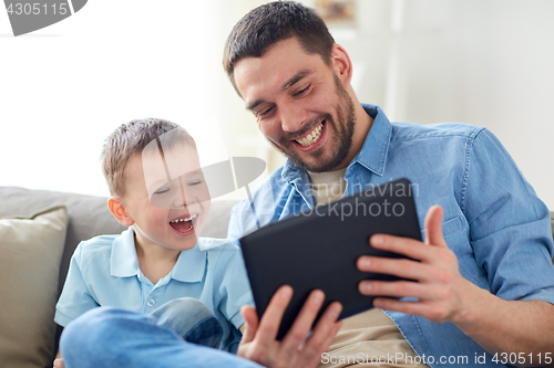 Image of father and son with tablet pc playing at home