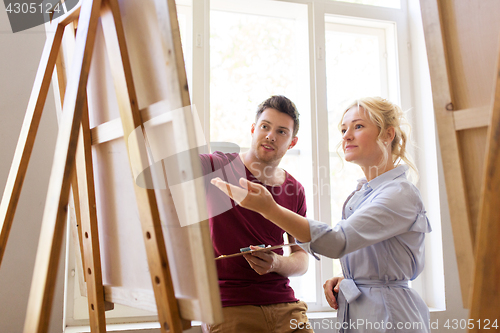 Image of artists with palette and easel at art school