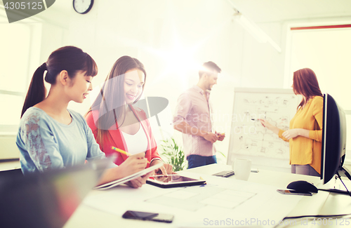 Image of happy creative team with tablet pc at office