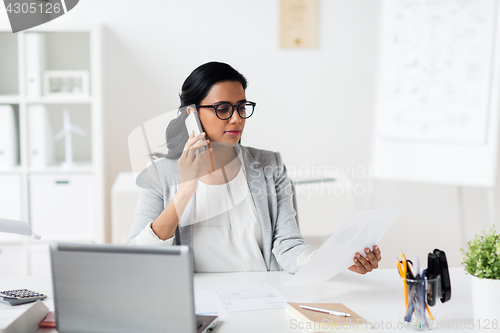 Image of businesswoman calling on smartphone at office