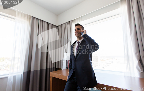 Image of businessman calling on smartphone at hotel room