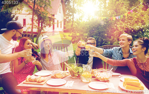 Image of happy friends having party at summer garden