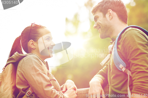 Image of smiling couple with backpacks in nature