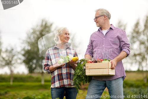 Image of senior couple with box of vegetables on farm