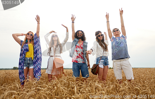 Image of happy young hippie friends dancing on cereal field