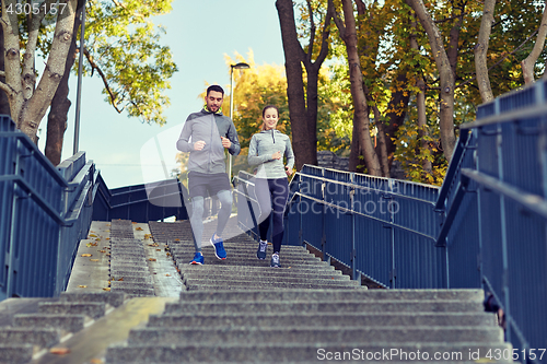 Image of happy couple running downstairs in city