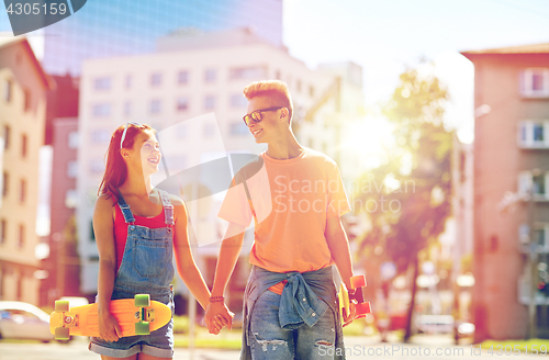 Image of teenage couple with skateboards on city street