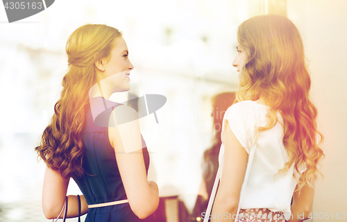 Image of happy women with shopping bags at shop window