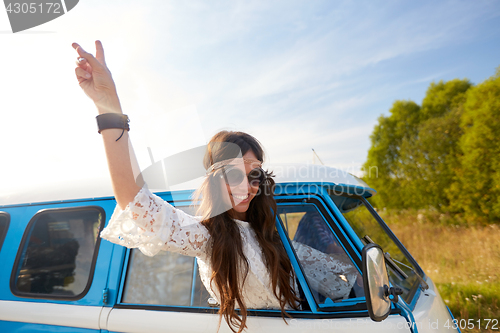 Image of happy hippie woman showing peace in minivan car