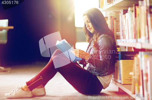 Image of high school student girl reading book at library