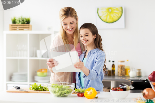Image of family cooking dinner using tablet pc at kitchen