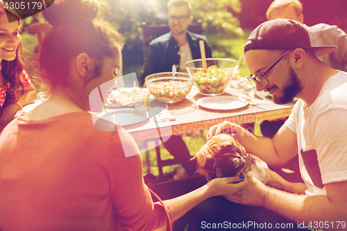 Image of happy friends having dinner at summer garden party