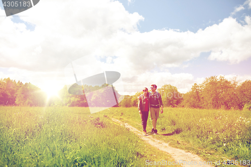 Image of happy couple with backpacks hiking outdoors