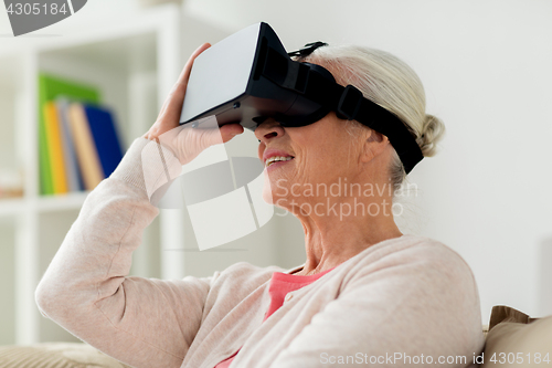 Image of old woman in virtual reality headset or 3d glasses