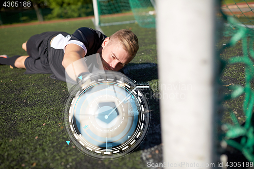 Image of goalkeeper with ball at football goal on field