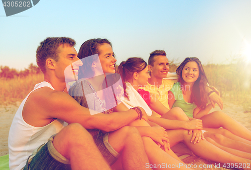 Image of smiling friends in sunglasses on summer beach