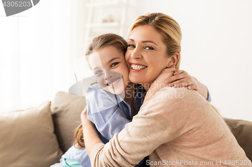 Image of happy smiling family hugging on sofa at home