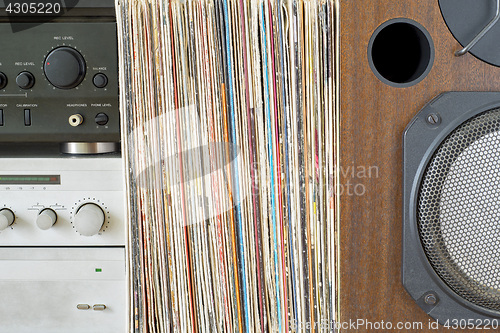 Image of Retro receiver, amplifier stack of vinyl records near the sound speaker