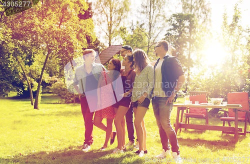 Image of happy teenage friends talking at summer garden