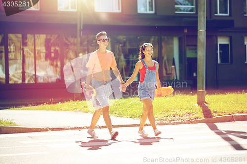 Image of teenage couple with skateboards on city street