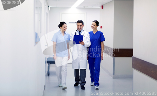 Image of group of smiling medics at hospital with clipboard