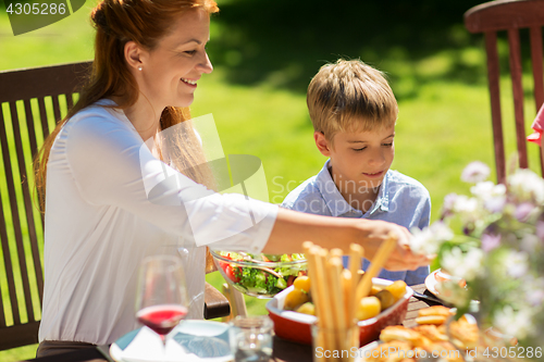 Image of happy family having dinner or summer garden party