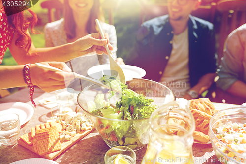 Image of happy friends having dinner at summer garden party