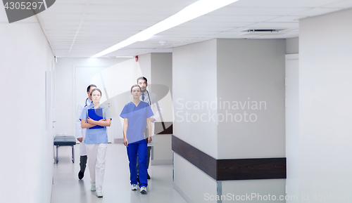 Image of group of medics or doctors walking along hospital