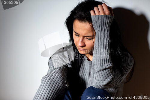 Image of unhappy woman crying on floor