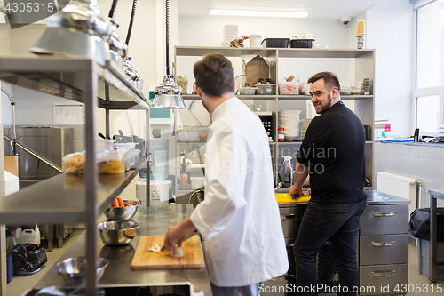 Image of chef and cook cooking food at restaurant kitchen