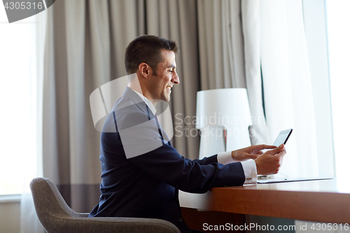 Image of businessman with tablet pc working at hotel room