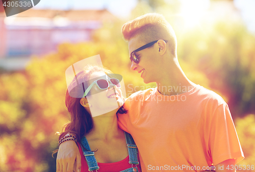 Image of happy teenage couple looking at each other in park
