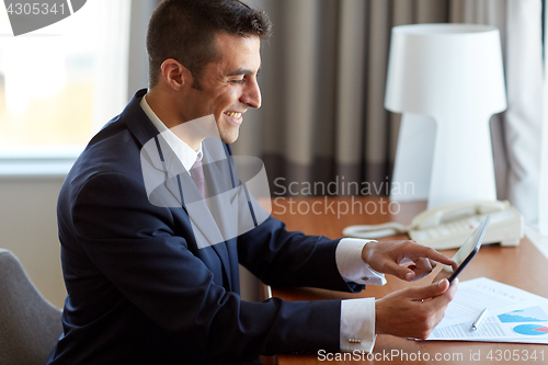 Image of businessman with tablet pc working at hotel room