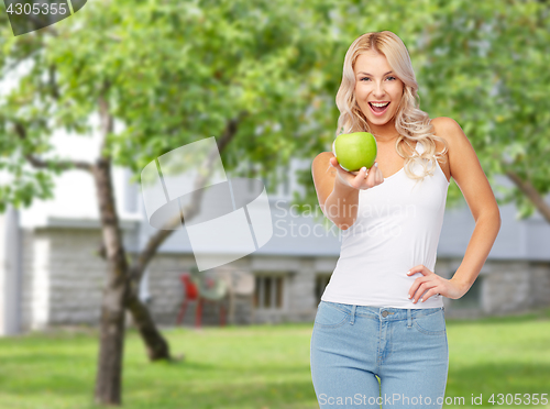 Image of happy beautiful young woman with green apple