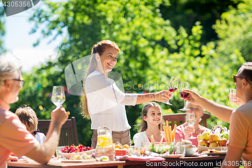 Image of happy family having dinner or summer garden party