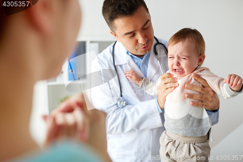 Image of doctor or pediatrician with crying baby at clinic