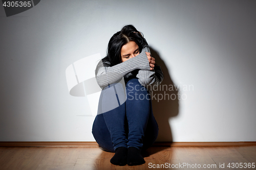 Image of unhappy woman crying on floor at home