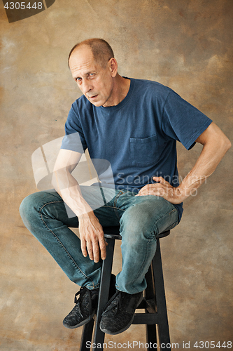 Image of Worried mature man sitting at studio