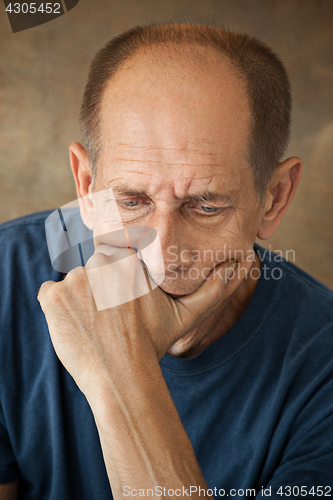 Image of Worried mature man touching his head.