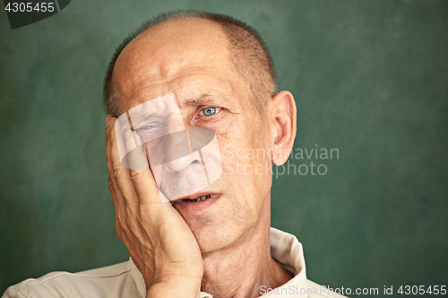 Image of Worried mature man touching his head.