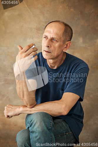 Image of Worried mature man sitting at studio