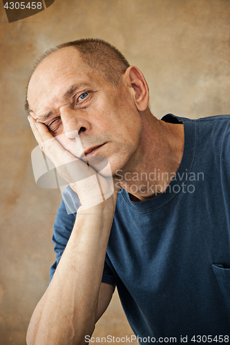 Image of Worried mature man touching his head.