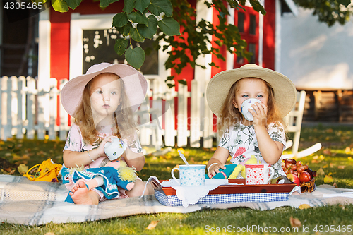 Image of Two little girls sitting on green grass